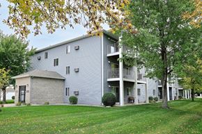 Fargo apartment for rent - An exterior of a three level apartment with a large grass area out front. Fargo, ND Flagstone Apartments.
