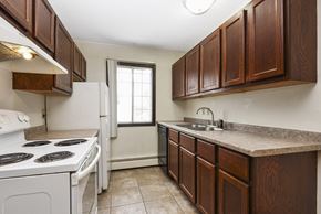Fridley apartment for rent - Fridley, MN Georgetown Apartments. A kitchen with brown cabinets and white appliances