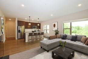 Eagan apartment for rent - Eagan, MN Glen Pond Addition Apartment. A living room with a couch, coffee table, and large window with a kitchen in the background.