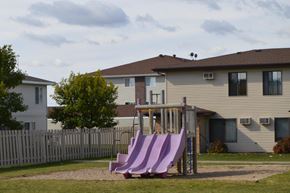 Fargo townhouse for rent - a playground with a set of slides in front of a house. Fargo, ND Hazelwood Townhomes