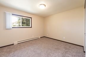 Bismarck apartment for rent - Bismarck, ND Highland Meadows Apartments. An empty bedroom with a large window and carpet