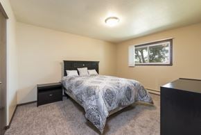 Bismarck apartment for rent - a bedroom with a bed and a window. Bismarck, ND Highland Meadows Apartments