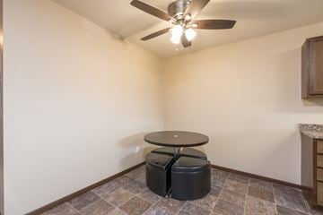 Bismarck apartment for rent - a living room with a ceiling fan and a table with two stools