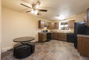 Bismarck apartment for rent - an empty kitchen with a ceiling fan and a table. Bismarck, ND Highland Meadows Apartments
