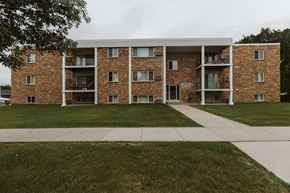 Crookston apartment for rent - Grand Forks, ND Hoven Lane Apartments. an exterior view of a brick apartment building with grass and a sidewalk