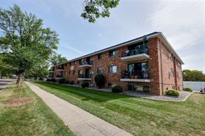 Fargo apartment for rent - the exterior of a brick apartment building with a sidewalk and grass. Fargo, ND Martha Alice Apartments