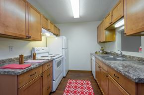Fargo apartment for rent - a kitchen with wood cabinets and white appliances and granite counter tops. Fargo, ND Maybrook Apartments