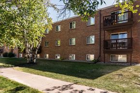 Grand Forks apartment for rent - Grand Forks, ND Mayfair Apartments. An exterior of a three level apartment building with a sidewalk out front.