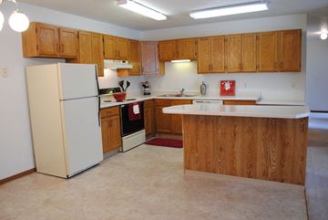 West Fargo apartment for rent - an empty kitchen with white appliances and wooden cabinets