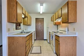 Fargo apartment for rent - a kitchen with white appliances and wooden cabinets. Fargo, ND Prairiewood Meadows