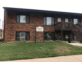 Bismarck apartment for rent - a brick building with a sign in front of it. Bismarck, ND Riverpark Apartments