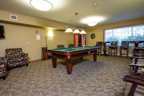 Fargo apartment for rent - a pool table with chairs around it and a window. Fargo, ND Crossroads Apartments