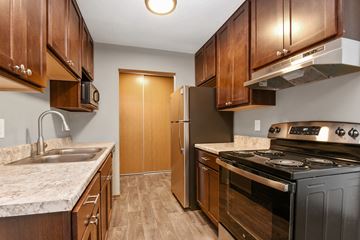 New Brighton apartment for rent - a kitchen with wooden cabinets and stainless steel appliances