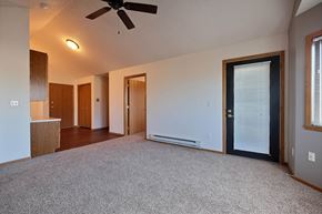 Fargo apartment for rent - a living room with a patio door and office space in the background. Fargo, ND Somerset Apartments