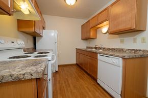 Fargo apartment for rent - a kitchen with white appliances and wooden cabinets. Fargo, ND Southwind Apartments