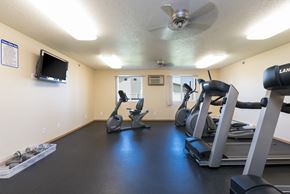 Bismarck apartment for rent - a gym with treadmills and other exercise equipment and a tv.Bismarck, ND Sunset Ridge Apartments