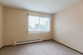 Crookston apartment for rent - Grand Forks, ND Twin Drive Apartments. A bedroom with a window and a carpeted floor