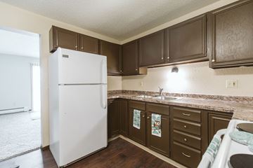 Crookston apartment for rent - an image of a kitchen with white appliances and dark cabinets