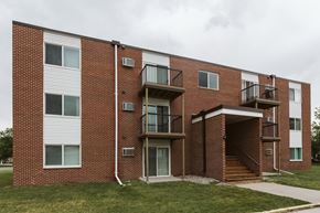 Crookston apartment for rent - Grand Forks, ND Twin Drive Apartments. An exterior of a brick apartment building with stairs and grass