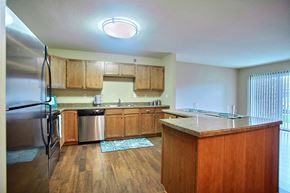 Fargo apartment for rent - a kitchen with stainless steel appliances and wooden cabinets. Fargo, ND Wolf Creek Apartments