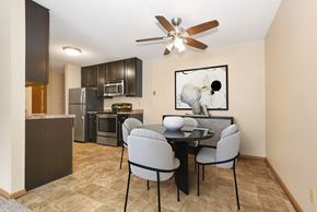 Anoka apartment for rent - a dining area with a table and chairs and a kitchen with stainless steel appliances. Anoka, MN Dellwood Estates