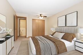 Anoka apartment for rent - a bedroom with a large bed and a ceiling fan. Anoka, MN Dellwood Estates