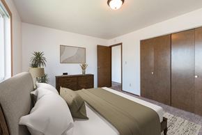 Bismarck apartment for rent - Bismarck, ND Brentwood II Apartments. A bedroom with a bed and dresser Brentwood II| Bismarck, ND