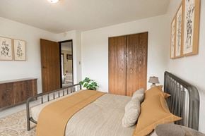 Bismarck apartment for rent - Bismarck, ND Eagle Sky I. A bedroom with a bed and a wardrobe. The yellow accents on the bed make for a bright energetic room.