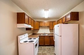 Bismarck apartment for rent - Bismarck, ND Eastbrook Apartments. A kitchen with a stove refrigerator and sink
