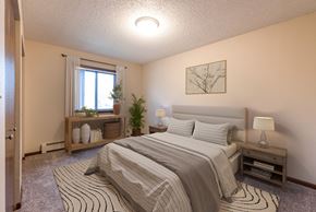 Bismarck apartment for rent - a bedroom with a bed and window. Bismarck, ND Newgate Apartments