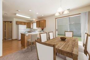 Bismarck apartment for rent - Bismarck Pebble Creek Apartments.with a glass sliding door that allows natural light to fill the space. The room showcases a well-appointed dining table, stylish seating, and a welcoming atmosphere for enjoyable meals and gatherings
