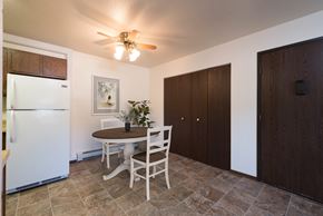 Bismarck apartment for rent - Bismarck, ND Rosser Apartments. A dining room with a table and two chairs. The overhead fan and light brighten the room. The entrance to the unit is next to a large closet for shoes and coats to be hung up.