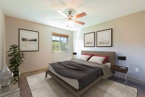 Bismarck townhouse for rent - Bismarck, ND Stonefield Townhomes.The room features a comfortable bed, stylish furnishings, and a warm color palette, creating a relaxing atmosphere. The window fills the room with bright natural light.