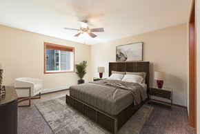 Bismarck apartment for rent - Bismarck, ND Stonefield Apartments. A bedroom with a bed and a ceiling fan
