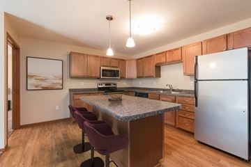 Bismarck apartment for rent - Bismarck, ND Stonefield Apartments. A kitchen with granite countertops and wooden cabinets