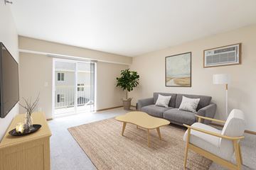 Bismarck apartment for rent - Bismarck, ND Sunset Ridge Apartments. A living room with beige walls and a sliding glass door that leads to a balcony. The room has modern furniture
