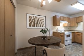 Bismarck apartment for rent - a kitchen and dining room with a table and chairs and a painting on the wall. Bismarck, ND Belmont East Apartments