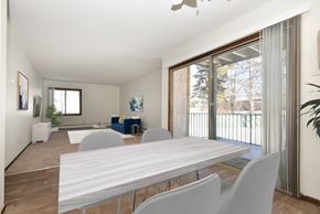Eagan apartment for rent - a dining area with a white table and chairs and a sliding glass door leading to a patio