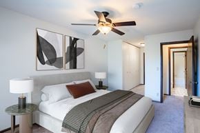 Eagan apartment for rent - a bedroom with a large bed and a ceiling fan. Eagan, MN Glen Pond Apartments