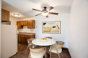 Eagan apartment for rent - a dining area with a table and chairs and a kitchen with a refrigerator. Eagan, MN Glen Pond Apartments