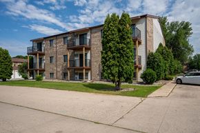 Fargo apartment for rent - A large apartment building with balconies and trees in front. Fargo, ND Hawthorn Apartments