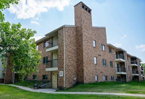 Grand Forks apartment for rent - A brick building with a balcony and a small entrance. Grand Forks, ND Columbia West Apartments