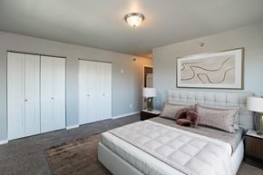 Fargo apartment for rent - a bedroom with a large white bed and white closets. Fargo, ND 29 West Apartments