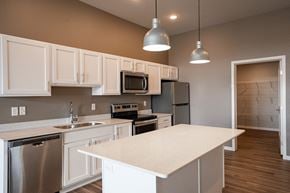 Fargo apartment for rent - a kitchen with white cabinets and stainless steel appliances. Fargo, ND 29 West Apartments