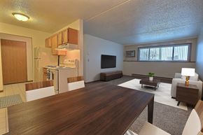 Fargo apartment for rent - a living room and kitchen with a wooden table. Fargo, ND Alden Pines Apartments