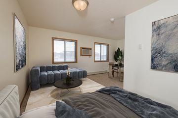 Fargo townhouse for rent - a bedroom with a bed and a couch and a living room with a dining room