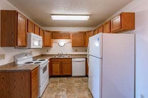 Fargo apartment for rent - a kitchen with white appliances and wooden cabinets. Fargo, ND Auburn II Apartments