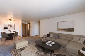 Fargo apartment for rent - a living room with a couch and a coffee table and a dining room. Fargo, ND Auburn II Apartments