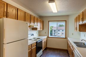 Fargo apartment for rent - Fargo, ND Bayview Apartments. A kitchen with white appliances and wooden cabinets