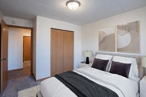 Fargo apartment for rent - a bedroom with a bed and a closet and a door to a bathroom. Fargo, ND Bella Vista Apartments